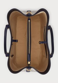 Strukturalna torba tote z granatowym skórzanym wykończeniem. Wnętrze wykonane z beżowej tkaniny zawiera centralną kieszeń na zamek, boczne kieszenie wsuwane oraz złote akcesoria.