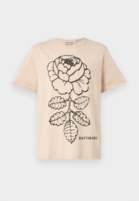 Beige bomull T-skjorte med et stort svart rose- og bladmotiv, med en etikett som leser "marimekko" trykket under grafikken.