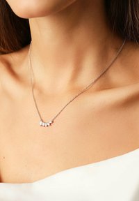 Silberne Halskette mit fünf klaren, marquise-förmigen Steinen in einem geschwungenen Design. Dünne Kette und minimalistischer Verschluss, der auf der Haut liegt.