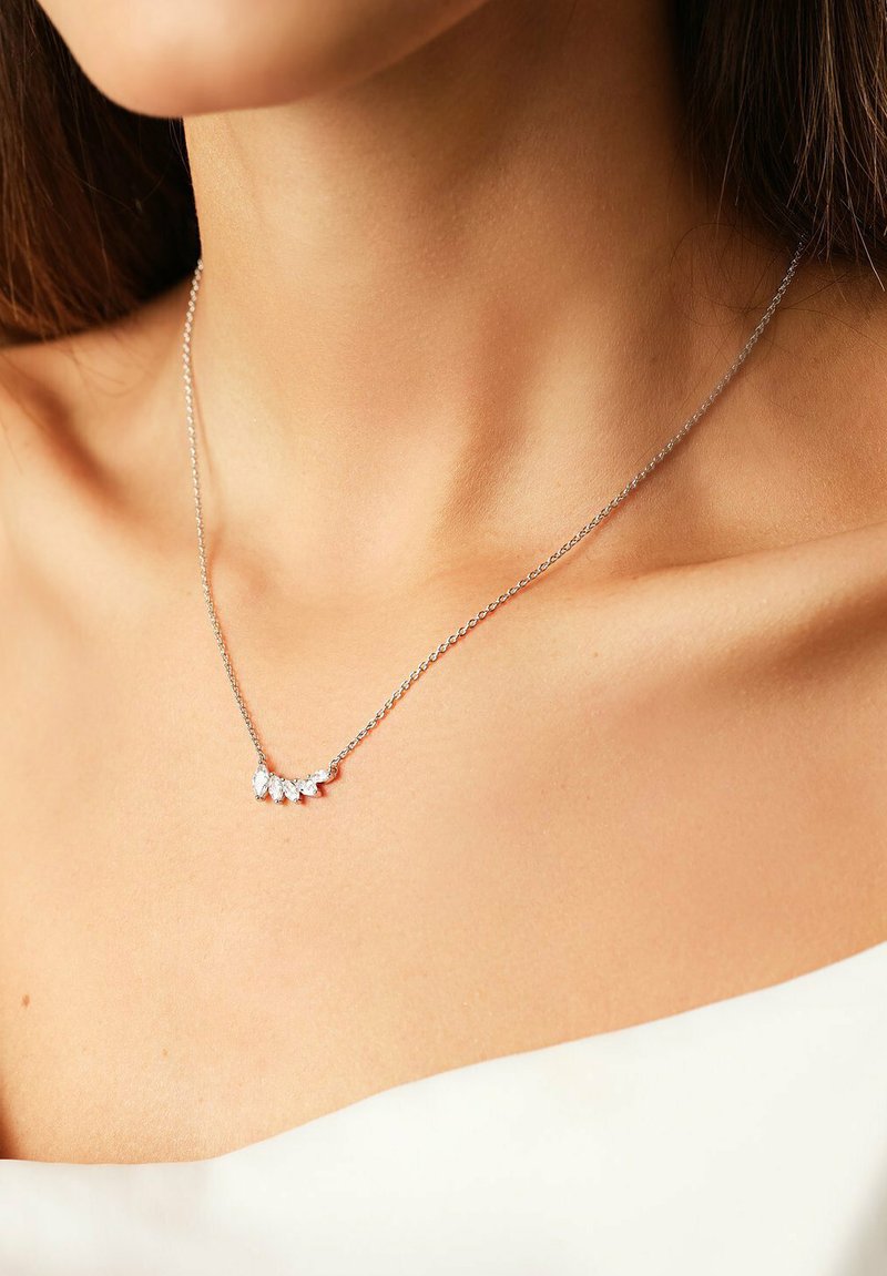Silberne Halskette mit fünf klaren, marquise-förmigen Steinen in einem geschwungenen Design. Dünne Kette und minimalistischer Verschluss, der auf der Haut liegt.