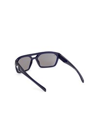 Lunettes de sport bleu foncé avec de larges branches et des verres teintés gris, inclinées sur fond blanc.
