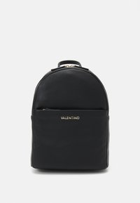 Black leather backpack with rounded top, textured finish, front zip pocket, and gold logo detailing. Zipper closure on the main compartment.