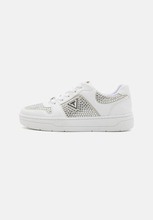 White sneakers with silver studs and triangle logo detail. Smooth leather upper, textured accents, and rubber sole.