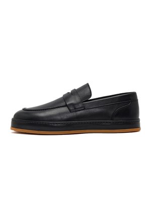 Mocasín slip-on de cuero negro con banda tipo penny, detalles cosidos y suela de goma marrón a contraste, vista lateral sobre fondo blanco.