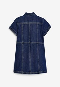 Tummansinisestä denimpuvusta, jossa on lyhyet hihat, jäsennelty muotoilu saumoineen ja kaulus. Ei näkyviä kuvioita tai metalliosia.