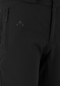 Close-up van zwarte broek met een ritszak op de dij en een subtiel driehoekig logo boven de zak.