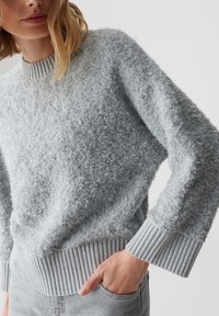 Grauer strukturierter Pullover aus einem weichen, flauschigen Stoff. Verfügt über einen gerippten Kragen und Bündchen sowie ein lässiges Schnittdesign.