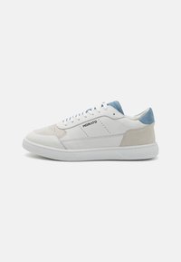 Zapatillas de deporte de cuero blanco con acentos de ante en beige y azul claro. Cuentan con una puntera perforada, cordones redondos y una suela de goma texturizada.