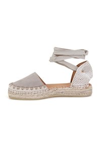 Espadrille en daim gris avec un talon en textile tissé, des sangles élastiques à la cheville, une semelle intermédiaire en jute et une semelle intérieure en cuir lisse.