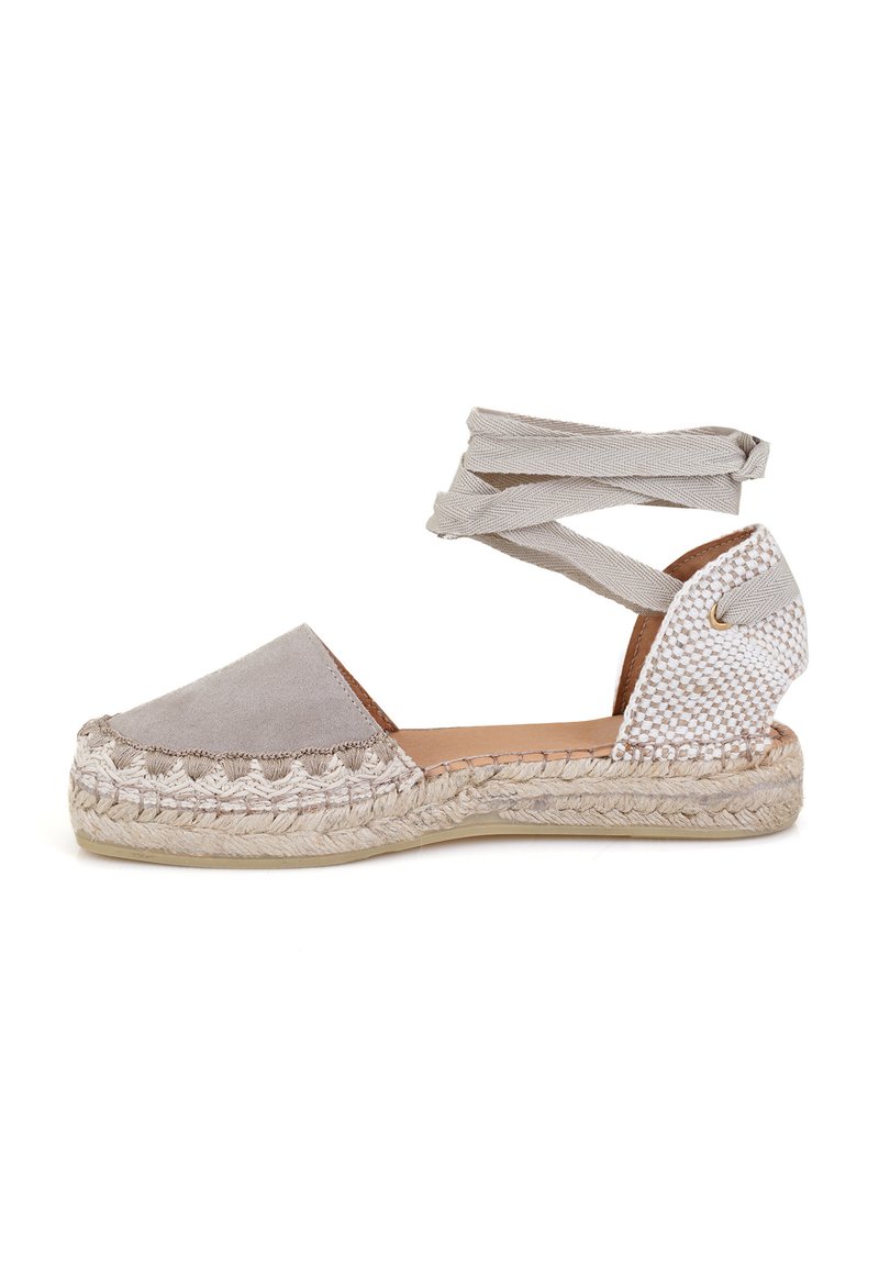 Espadrille en daim gris avec un talon en textile tissé, des sangles élastiques à la cheville, une semelle intermédiaire en jute et une semelle intérieure en cuir lisse.
