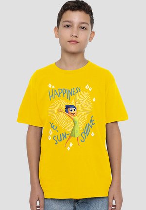 Junge, der ein leuchtend gelbes T-Shirt mit einem Joy-Charakter und dem Text "Happiness is sunshine" vor einem schlichten grauen Hintergrund trägt.