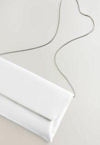 Fehér selyem clutch barna béléssel, ezüst lánc pánttal és hajtókával, az éle mentén elegáns ezüst díszítéssel.