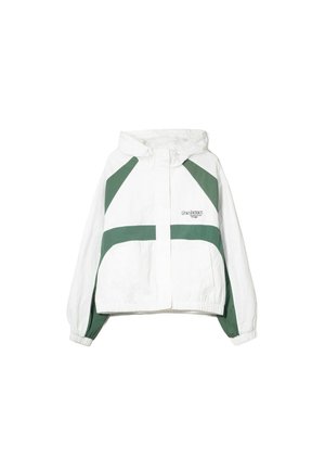 Veste blanche avec des blocs de couleur géométriques verts, dotée d'une capuche, de poignets élastiques et d'une fermeture éclair à l'avant. Tissu léger avec une finition mate.