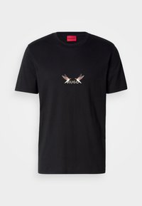 Svart bomull t-skjorte med et frontgrafikk som har ordet "HUGO" og to stiliserte fugledesign i lyse og mørke farger.