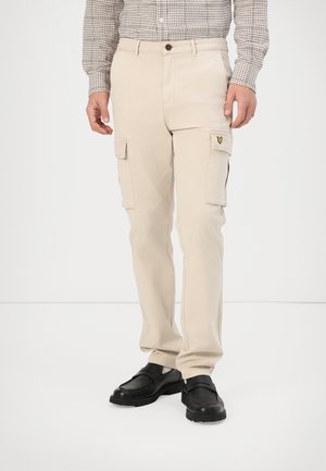 Beige cargo pants with side pockets, made of cotton. Features a button closure, straight legs, and a small logo on the left pocket.