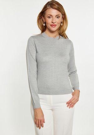 Pulover lung, gri deschis, cu mâneci lungi și guler rotund, cu textură ribbed vertical. Asortat cu pantaloni albi, design minimal, fără modele.