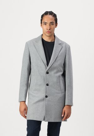 Abrigo de mezcla de lana gris con solapas muesca, tres botones y bolsillos laterales. La tela tiene una textura suave y un corte a medida.