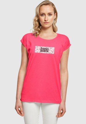 Pink cotton t-shirt with short sleeves featuring a rectangular graphic that says "Strong Woman" in black on a light pink background.
