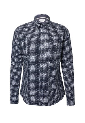 Chemise boutonnée bleu marine à manches longues, avec un col écarté et un motif de pois blancs irréguliers.