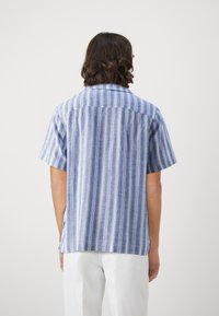 Short-sleeve shirt featuring vertical blue and white stripes, lightweight fabric with a relaxed fit, and a simple collar design.
