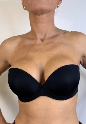 Sostenedor negro sin tirantes con copas suaves, forma contorneada y un cierre frontal sencillo. Fabricado con una tela mate y elástica.