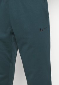 Nike Performance TAPER - Tracksuit bottoms - deep jungle