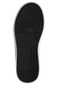 Schwarze Gummisohle mit strukturiertem Griffmuster. Verfügt über ein geprägtes DC-Logo in einem Quadrat nahe der Ferse. Der Rand hat weiße Akzente.