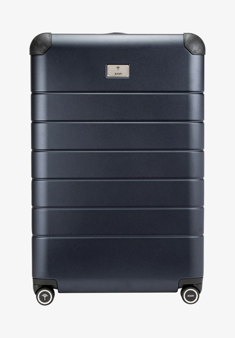 Valise rigide marine avec des rainures verticales, des protecteurs d'angle en caoutchouc, quatre roues noires et un logo argenté à l'avant.