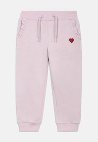 Világos rózsaszín melegítőnadrág bordázott mandzsettákkal, húzózsinóros derékpánttal, fodros oldalzsebekkel és piros szív emblémával az elején.