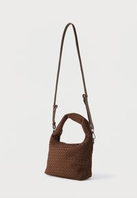 Sac à main tressé marron avec une surface texturée, une poignée courte et une longue bandoulière réglable pour des options de port polyvalentes.
