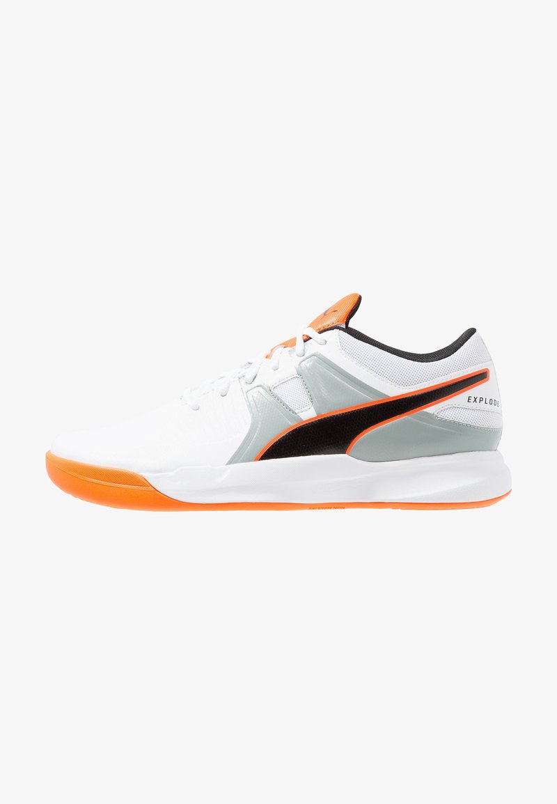 Baskets basses blanches avec semelle orange, logo Puma noir et orange, accents gris et lacets blancs.