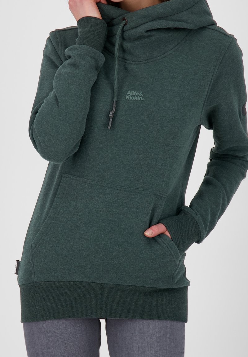 Sudadera con capucha verde hecha de tela suave, con bolsillo canguro, puños acanalados y un logo bordado en el pecho.