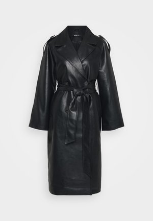Sort faux læder lang frakke med brede slag, dobbeltradede knapper, bæltestrop i taljen og skulderstropdetaljer på en hvid baggrund.