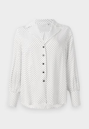 White long-sleeve blouse with black polka dots, black buttons down the front, a collar, and wide cuffs on the sleeves.