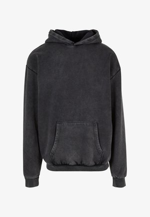 Crna oversized hoodie izrađena od mekog, teksturiranog materijala. Ima prednji kenguru džep i kapuljaču s podešavanjem. Rebrasti manžeti i donji rub.