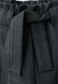 Material negru cu dungi subțiri verticale albe, având o talie adunată și un detaliu cu fundă din material în față. Textură moale.