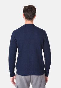 Maglione lavorato a maglia blu navy, con texture a coste, maniche lunghe, scollo rotondo, design semplice, colore uniforme, senza ornamenti visibili.