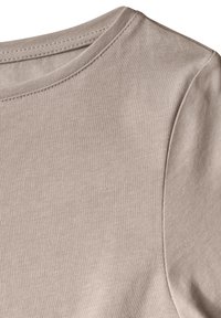 Beige bomullströja med rund halsringning och mjuk textur. Sömmarna är synliga längs kragen och axelsömmarna.