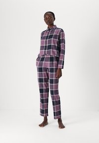 Paars en marineblauw geruite pyjama set met een knoopsluiting shirt met kraag en broek met elastische tailleband. Zachte katoen stoftextuur.