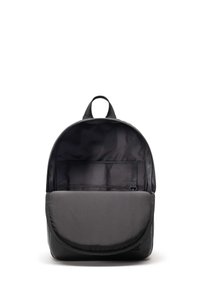 Sac à dos en tissu noir avec une forme arrondie, un rabat avant et une poche intérieure. Texture lisse et design minimaliste.
