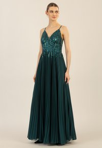 Langes türkisfarbenes Abendkleid mit einem plissierten Rock und einem verzierten Oberteil, das dekorative Pailletten und einen V-Ausschnitt sowie dünne Träger bietet.