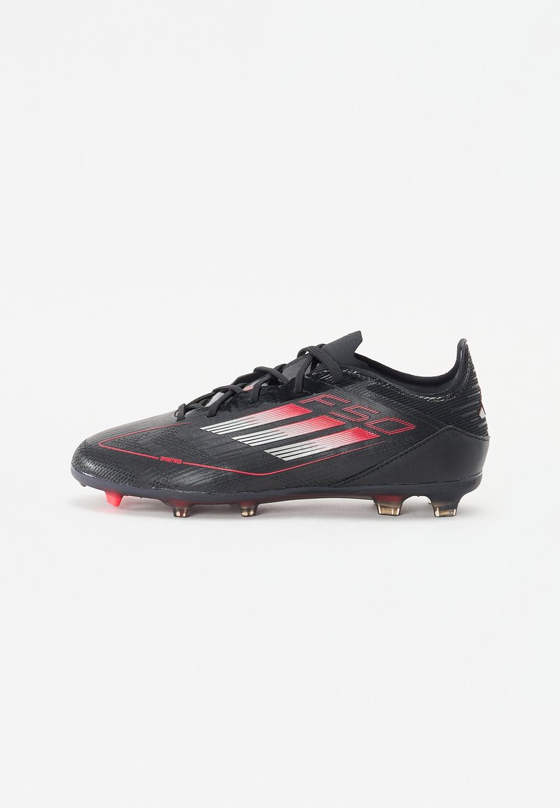 Black soccer cleat with a sleek design, featuring red accents, textured upper, and multiple studs for traction on the sole.