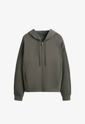 Hooded zip-up jacket in olive green. Features a textured fabric, relaxed fit, and ribbed cuffs. Double drawstrings at the hood.