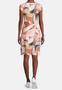 Sukienka w kwiatowy wzór w pastelowych kolorach, z krótkim rękawem, do kolan, wykonana z miękkiego materiału. W zestawie z białymi trampkami.