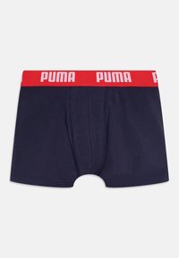 Boxer shorts navy avec une ceinture élastique rouge arborant le logo "PUMA" en blanc. Texture de tissu lisse avec une coupe ajustée et sans motifs.