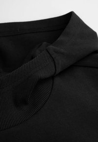 Czarny sweatshirt z wysokim kołnierzem. Posiada teksturowane akcenty w prążki oraz gładki materiał. Miękka, elastyczna tkanina bez widocznych wzorów.