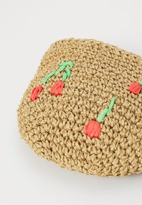 Geflochtene Strohtasche mit einer strukturierten, natürlichen Oberfläche und roter Tulpenstickerei sowie grünen Akzenten. Abgerundete Form mit kompaktem Design.