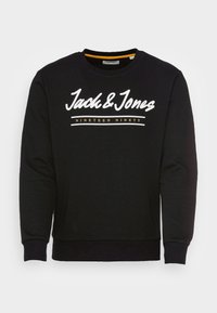 Sudadera negra de algodón, con cuello redondo, mangas largas y texto blanco con "Jack & Jones" y "NINETEEN NINETY" en acentos amarillos.