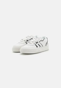 White sneakers with a textured rubber sole, perforated toe detail, and contrasting black accents on the sides and laces.