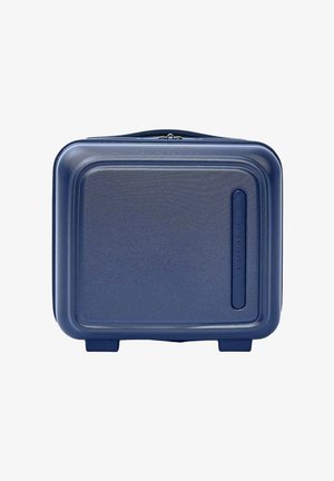 Valise rigide compacte bleu marine avec coins arrondis et surface texturée, posée debout sur deux petits pieds.